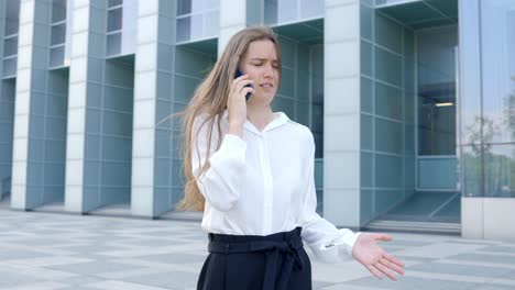 Young-businesswoman-talking-on-the-phone-outside-of-office