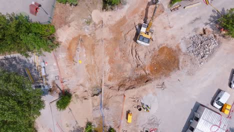 Top-down-aerial-view-of-a-construction-site-with-a-bulldozer-doing-the-digging