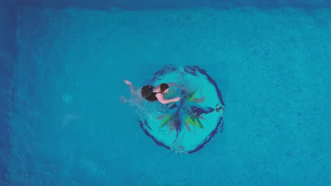 Mother-and-son-family-swimming-at-pool-aerial-view