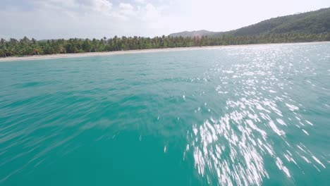 Drone-flying-around-luxury-sailboat-and-towards-Playa-Rincon-Caribbean-beach,-Las-Galeras-in-Dominican-Republic