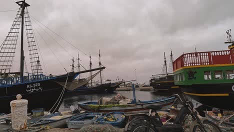 Djerba-port-with-fishermen-boats,-nets-and-touristic-pirate-galleon-ships,-second-part