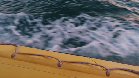 Gelbes-Aufblasbares-Schlauchboot,-Das-Auf-Dem-Wasser-Schwimmt-Und-über-Bord-Schaut
