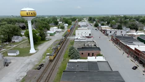 State-Center,-Iowa-downtown-with-train-passing-through-town-and-drone-video-stable