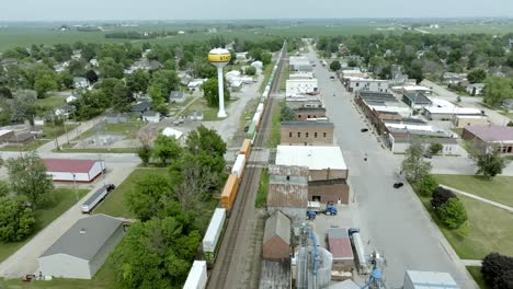 State-Center,-Innenstadt-Von-Iowa-Mit-Einem-Zug,-Der-Durch-Die-Stadt-Fährt,-Und-Einem-Drohnenvideo,-Das-Einfährt