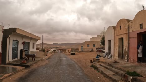 Driving-car-across-Tunisian-remote-rural-mountain-village-on-cloudy-stormy-day-in-Tunisia