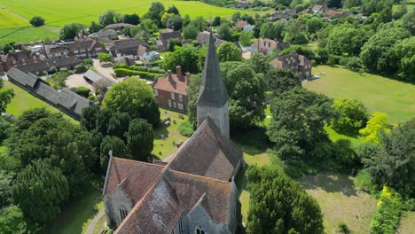 An-aerial-pull-out-shot-over-Ickham-village,-pulling-away-to-reveal-St-John-the-Evangelist-church