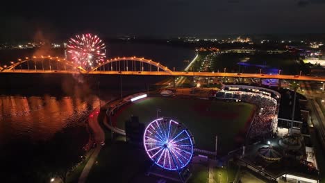 Davenport,-Iowa-at-night-with-fireworks-going-off-after-Quad-Cities-River-Bandits-game-and-drone-video-stable-close-up
