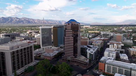 Eine-4k-weite-Drohnenaufnahme,-Die-Auf-Ein-Gebäude-In-Der-Innenstadt-Von-Tucson,-Arizona,-Zustößt,-Mit-Den-Bergen-Im-Hintergrund