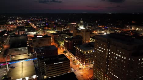 Davenport,-Torre-Del-Reloj-De-Iowa-Por-La-Noche-Con-Video-De-Drones-Moviéndose-En-Edificios-Pasados