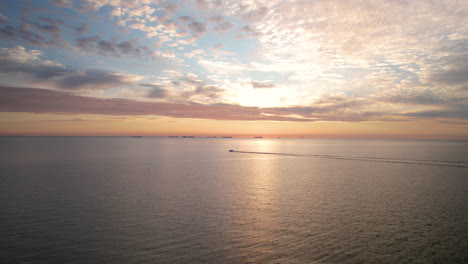 Dramatischer,-Farbenfroher-Sonnenaufgang-Aus-Der-Luft-über-Dem-Endlosen-Meer-Mit-Vereinzelten-Wolken-Und-Fernsicht-Auf-Trawlerboote-Und-Motorbootfahrten