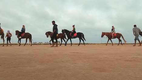 Tourists-riding-horses-and-dromedary-camels-in-a-row-through-Tunisia-desert