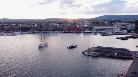 Aerial-Oslo-Sunset-Harbor-Scene,-big-Sailing-vessel-looking-to-dock