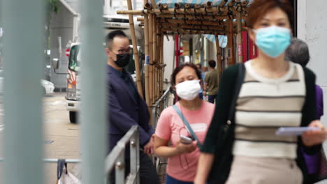 Statische-Aufnahme-Von-Menschen,-Die-Auf-Einem-Bürgersteig-Mit-Einer-Baustelle-In-Hongkong-Gehen