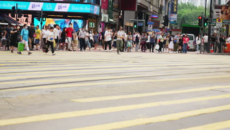 Static-shot-of-people-crossing-a-very-busy-road-on-the-zebra-crossings-in-Hong-Kong