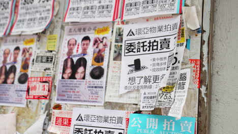 Toma-Estática-De-Folletos-Publicitarios-Colgados-En-Una-Pared-Escritos-En-Ideogramas-Chinos.