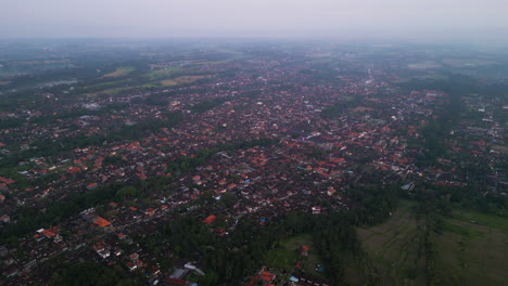 High-angle-drone-shot-over-Ubud-on-Bali-during-evening-with-dirty-climate-in-the-air---Overpopulation-and-hovering-fumes-at-sky
