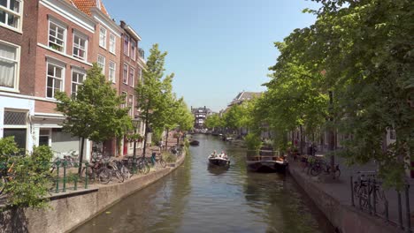 People-On-Motorboat-Sailing-Across-Canals-During-Summer-In-Leiden,-South-Holland,-Netherlands