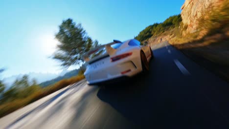 FPV-aerial-flying-behind-a-Porsche-911-driving-along-a-scenic-mountain-highway-in-Spain