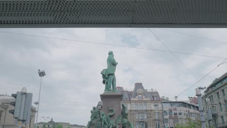 Tilt-down-camera-shot-of-a-weathered-bronze-statue-in-Zurich,-Switzerland