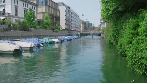 Zeitlupenclip-Eines-Kanals-Mit-Festgemachten-Booten-In-Der-Stadt-Zürich,-Schweiz