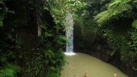 Aerial-view-of-stunning-waterfall-on-Bali-many-People-swimming-in-lake-during-sunny-day---Overpopulation-destroying-nature