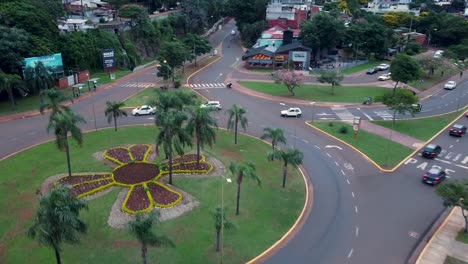 Cars-driving-through-roundabout-close-to-the-border-station-of-Argentina-and-Paraguay,-city-view-of-Posadas-at-sunset