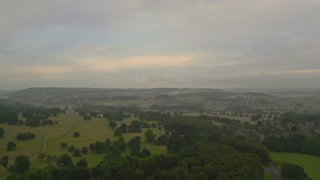 Eine-Rotierende-Ansicht-Von-Baumfeldern-Und-Hügeln-In-Der-Ferne-Bei-Sonnenaufgang