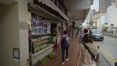POV--Asian-people-walking-on-street-with-supermarkets-on-bright-sunny-day