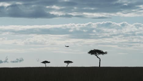 Slow-Motion-Shot-of-Aeroplane-prop-plane-with-propellors-flying-across-the-savannah-in-flight-over-trees,-African-adventure-travel-tourism-in-Maasai-Mara,-Kenya,-Africa-Safari-in-Masai-Mara