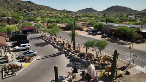 Rising-aerial-view-of-the-Rare-Earth-Gallery-parking-lot-in-Cave-Creek,-Arizona