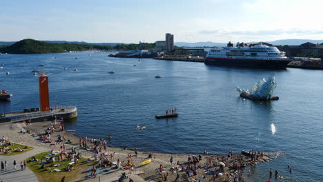 Oslo-Harbour-Scene-with-"She-Lies"-Sculpture-and-Cruise-ship-in-background,-Static-Slomo