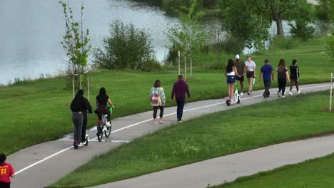 Menschen,-Die-Auf-Dem-Parkwanderweg-Spazieren-Gehen,-Rad-Fahren,-Roller-Fahren-Und-Sport-Treiben