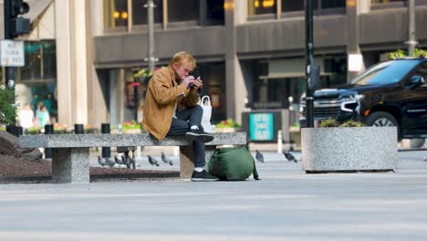 soft-focused-image-of-a-man-in-the-background-using-his-phone-while-commuters-are-walking-past-the-scene