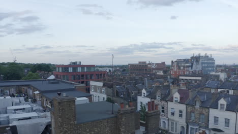 Low-urban-aerial-orbits-people-on-rooftop-patio-in-suburban-London-UK