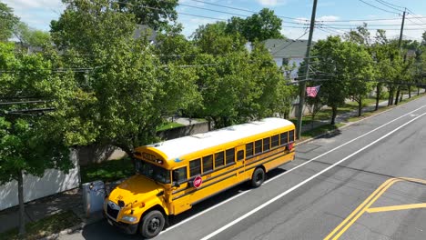 Aerial-view-showing-american-yellow-school-bus-parking-on-street-in-Tottenville-neighborhood-of-Staten-island-at-summer