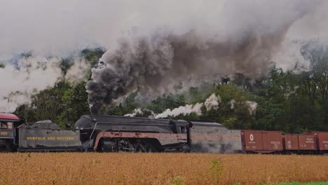 Eine-Seitenansicht-Eines-Güterzuges-Mit-Doppelkopf,-Der-An-Einem-Herbsttag-Vorbeifährt-Und-Rauch-Und-Dampf-Ausstößt