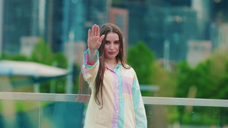 pretty-young-caucasian-woman-standing-with-outstretched-hand-showing-stop-sign,-preventing-you