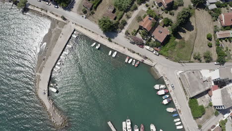 Aerial-rises-from-sleepy-village-boat-marina-on-Greek-Aegean-Sea-coast