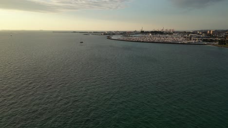 Aerial-flight-over-sea-of-Australia-with-Fremantle-Fishing-Boat-Harbour-in-Background-during-golden-sunset