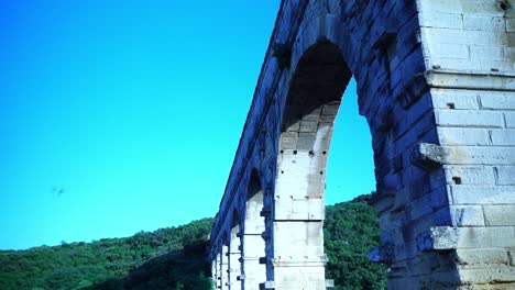 Birds-fly-by-and-over-the-Pont-du-Gard-in-France-in-the-sun