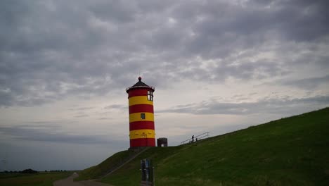 Kleiner-Leuchtturm-Auf-Einer-Düne-In-Norddeutschland-Mit-Dunkler-Abendstimmung-Am-Himmel