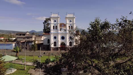 4k-horizontal-panning-drone-shot-of-the-Tucuso-church-in-the-city-of-Machachi,-Pichincha,-Ecuador,-on-a-sunny-day