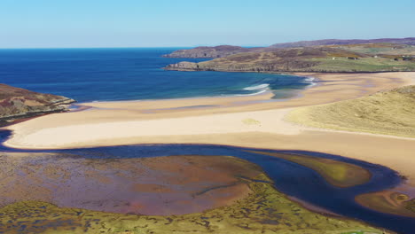 Aerial-shot-of-a-beautiful-Scottish-beach-on-the-North-Coast-500-on-a-summers-day