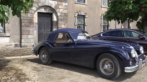 Elegancia-De-Otra-Era-El-Elegante-Jaguar-Xk120-En-Exhibición-En-Un-Patio-En-Waterford,-Irlanda,-En-Un-Rally-Vintage-Temprano-En-Una-Cálida-Mañana-De-Primavera