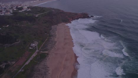 Vista-De-Drones-De-Praia-Do-Norte-Portugal-Con-Nazaré-En-El-Fondo,-Antena