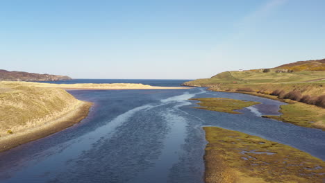 Aerial-reverse-shot-of-a-beautiful-river-and-estuary-in-the-north-of-Scotland-on-a-crisp-summers-day