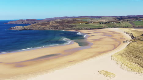 Aerial-shot-of-a-beautiful-beach-in-the-highlands-of-Scotland-on-a-stunning-summers-day