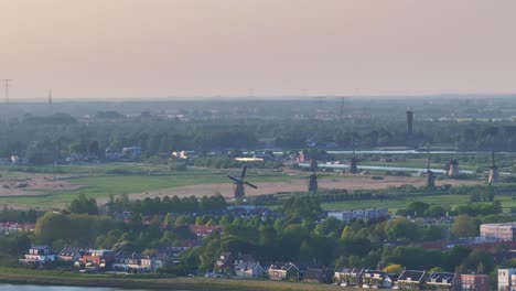 Vergrößerte-Drohnenschwenkaufnahme-Einer-Rotierenden-Windmühle-In-Kinderdijk,-Beleuchtet-Von-Der-Untergehenden-Sonne