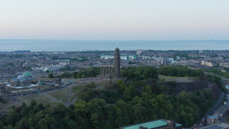 Luftaufnahme-Von-Menschenmengen,-Die-Sich-Auf-Dem-Calton-Hill-In-Edinburgh-Versammelt-Haben,-Mit-Der-Skyline-Der-Stadt-Im-Hintergrund