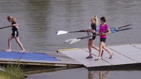 Mädchen-Nehmen-Ruder-Vom-Dock-Am-Ruderkanal-Für-Wasserrennen